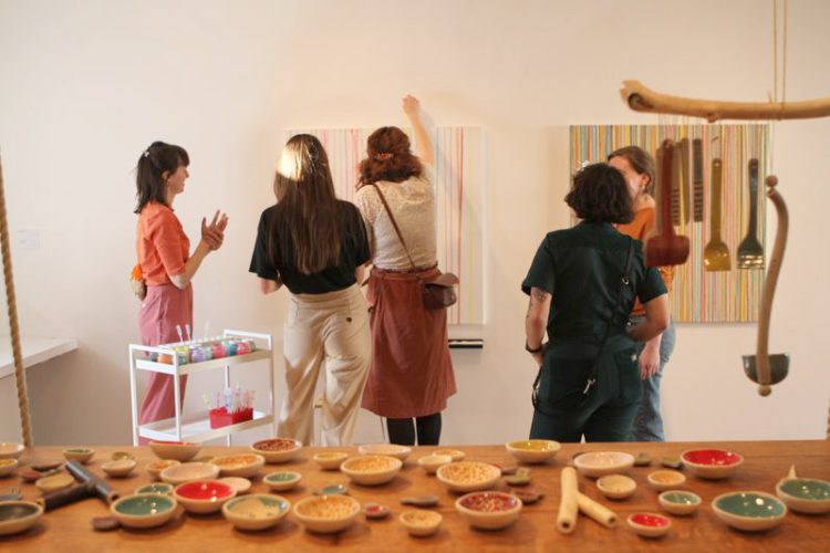 Toile vierge au départ, remplis par des spectateurs de gouttes de peinture qui coulent de haut en bas