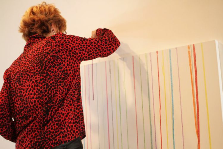 Toile vierge au départ, remplis par des spectateurs de gouttes de peinture qui coulent de haut en bas