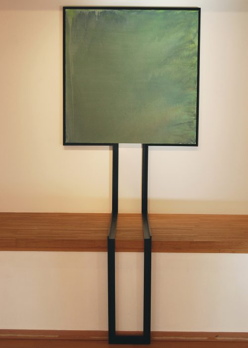 Toile aux teintes vert, carré, avec un cadre semblable a un tronc assis.