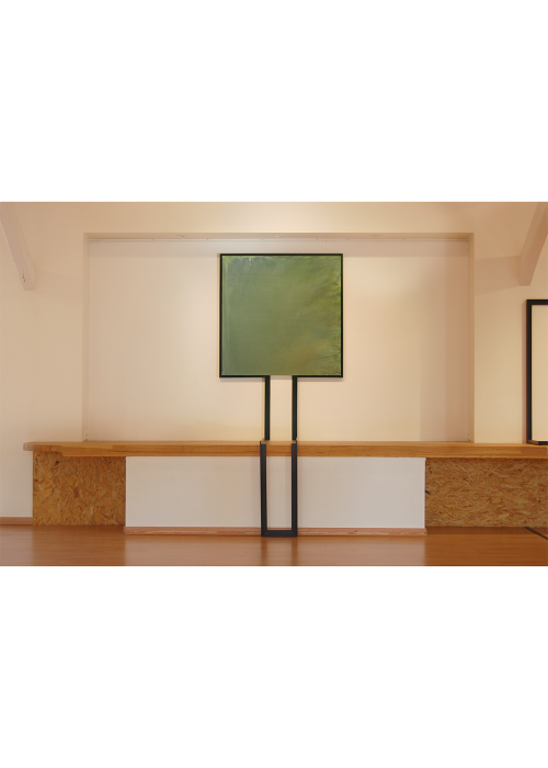 Toile aux teintes vert, carré, avec un cadre semblable a un tronc assis.