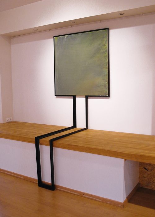 Toile aux teintes vert, carré, avec un cadre semblable a un tronc assis.