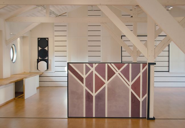 Toile reprenant les motifs des poutres en bois de la pièce avec un camaïeu de violet. Le cadre étant enrouler autour d'une poutre.