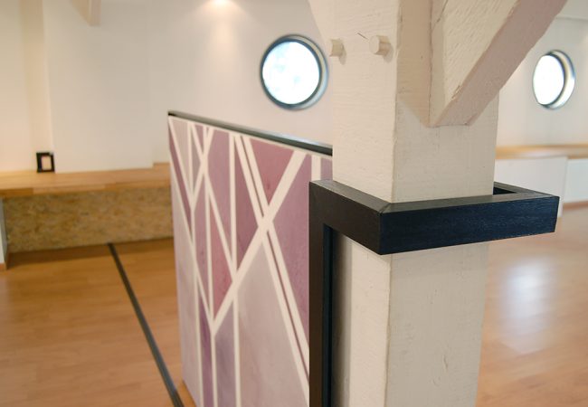 Toile reprenant les motifs des poutres en bois de la pièce avec un camaïeu de violet. Le cadre étant enrouler autour d'une poutre.