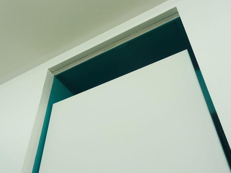 Toile blanche sur fond bleu au dessus d'une porte